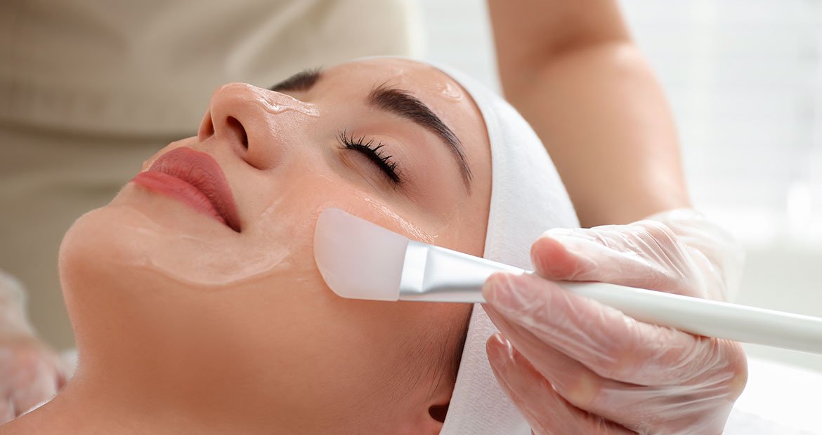 Mulher utiliza esfoliante químico em consultório